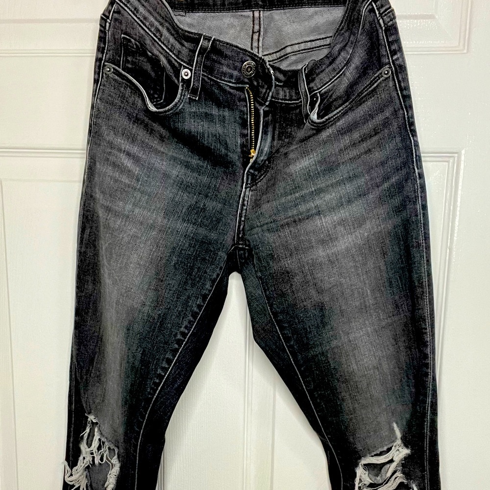 Levis black ripped skinny jeans, casually worn.